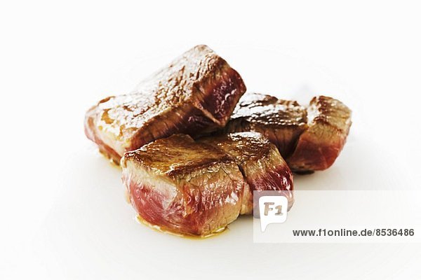 Seared Lamb Cubes on a White Background