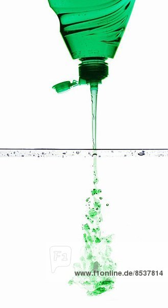 Grünes Spülmittel fliesst ins Wasser