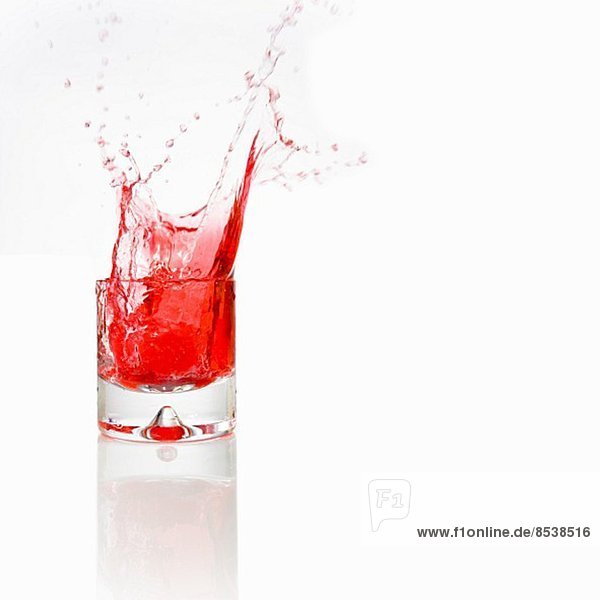 Rotes Wasser spritz aus Glas