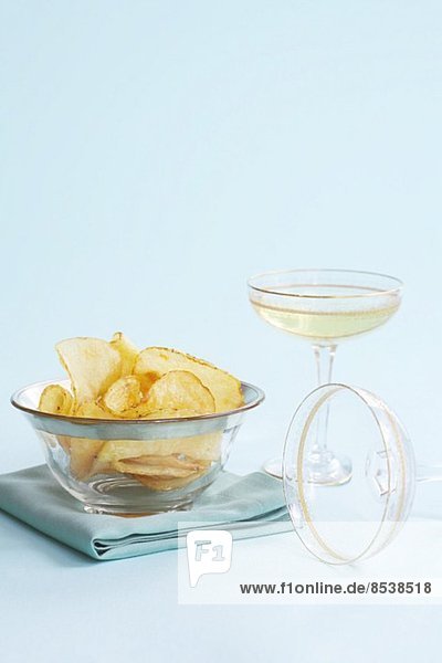 Kartoffelchips im Glasschälchen dazu Champagner im Glas