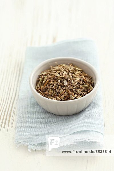 Aniseeds in a small bowl on a cloth