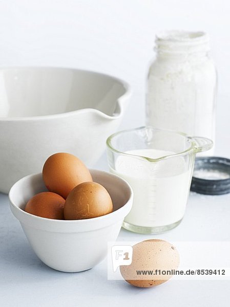 Assorted baking ingredients: eggs  milk  a mixing bowl