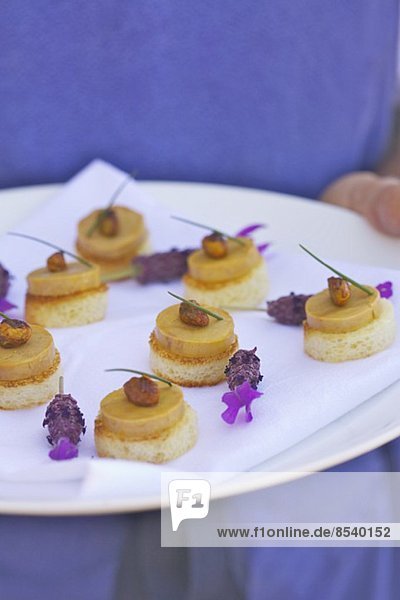 Toast-Häppchgen mit Foie Gras mit Lavendelblüten garniert
