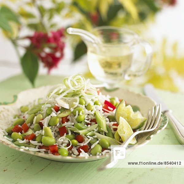 Rice salad with soy beans and lime wedges