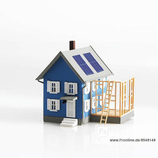 Ein Modell eines traditionellen Hauses  mit Terrasse oder Rahmen eines Anbaus.