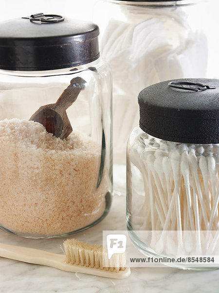 Sturdy glass storage jars for body scrub granules and for cottonwool and other personal grooming items.