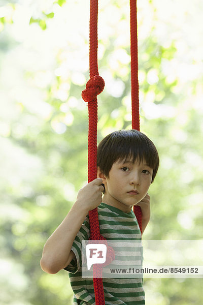 A child on a swing  playing outdoors.