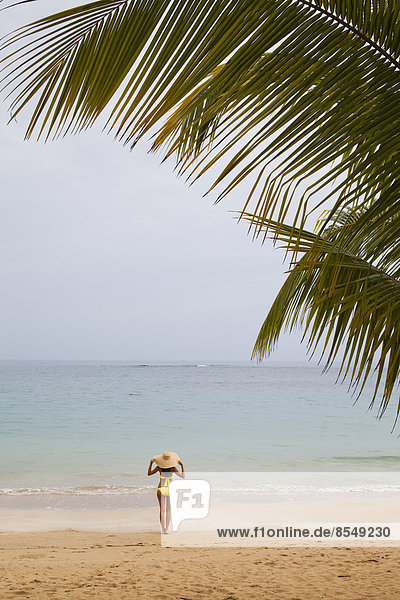 Eine junge Frau an einem abgelegenen Strand auf der Halbinsel Samana in der Dominikanischen Republik.