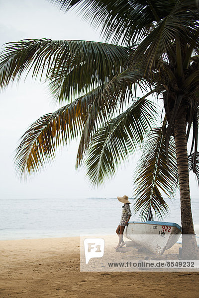 Eine junge Frau an einem abgelegenen Strand auf der Halbinsel Samana in der Dominikanischen Republik.