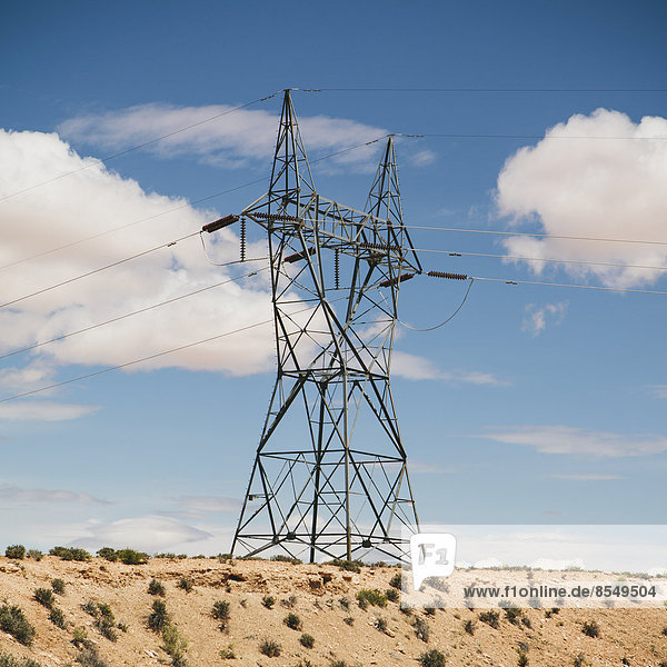 A tall pylon carrying power lines  in the desert near Tucson.