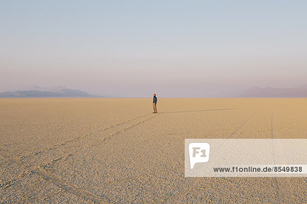 Die Figur eines Mannes in der leeren Wüstenlandschaft der Black-Rock-Wüste in Nevada.