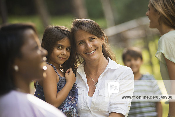 Eine Gruppe von Frauen und Kindern im Freien  lachend und lächelnd.