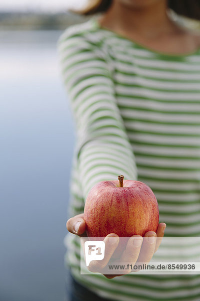 Detail eines neunjährigen Mädchens mit Bio-Apfel