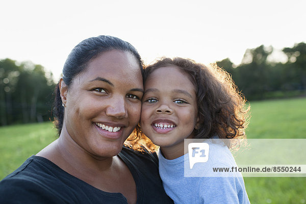 An adult woman and a child  mother and son  outdoors in evening light.