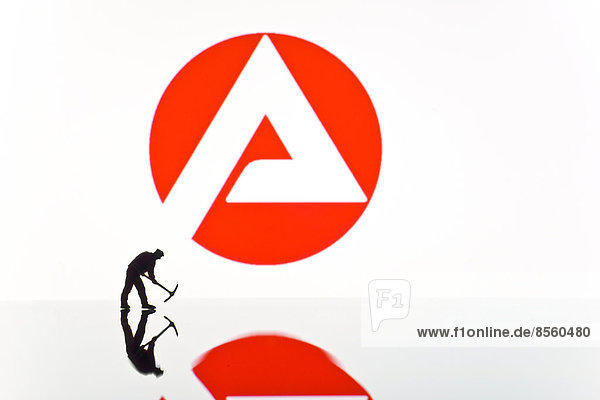 Bauarbeiterfigur vor dem Logo der Arbeitsagentur  Arbeitsamt
