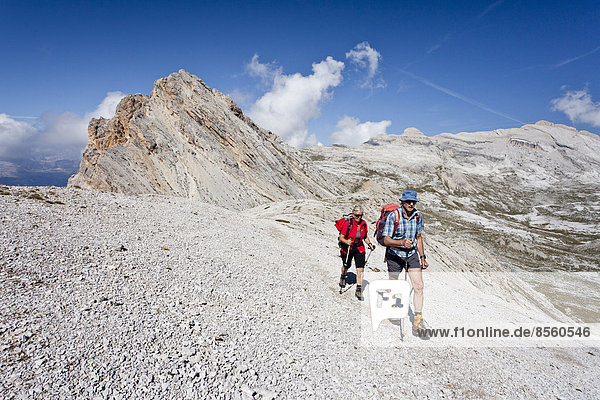Mountain climbers on the Lavarella Saddle  in front of Heiligkreuzkofel Mountain and Zehner Mountain  Val Badia  Dolomites  Alto Adige  Italy