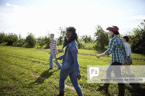 A group of young men and women in the fields of an organic farm.