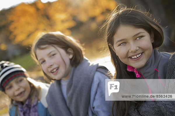 Drei junge Mädchen  Kinder  draußen an der frischen Luft. Herbstliches Laub.