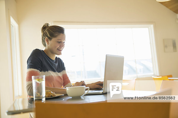Ein junges Mädchen in einem Café mit einem Laptop-Computer.