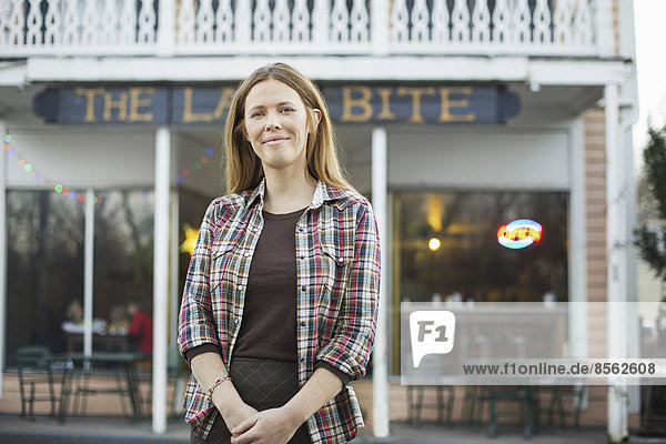 A coffee shop and cafe in High Falls called The Last Bite. A woman standing outside a high street cafe.