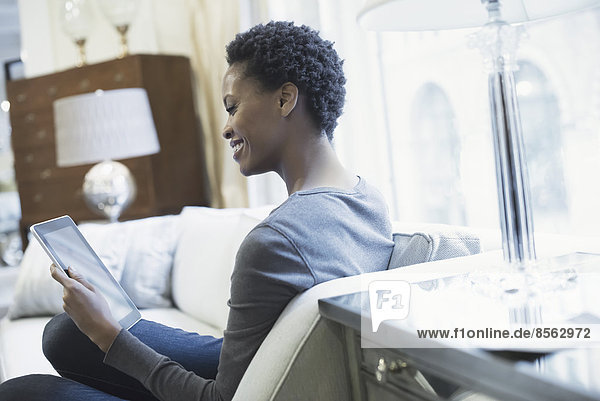 Woman relaxing at home with tablet
