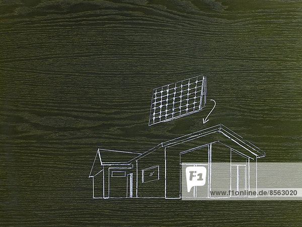 Ein Linienzeichnungsbild auf gemasertem Holz. Ein grünes Bauprojekt  ein Haus mit Sonnenkollektoren für das Dach.