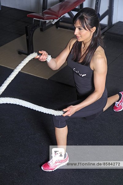 France  woman exercising with strings in a crossfit gymnasium..