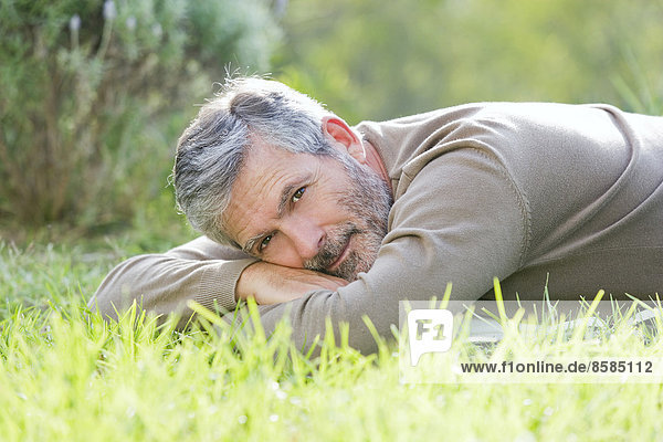 Mature man laying on the grass