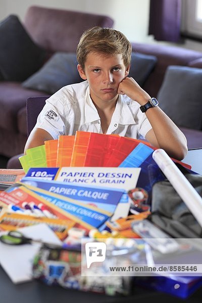 Frankreich  Junge und Mutter  Schulwerkzeug auf dem Wohnzimmertisch.