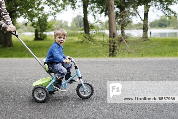 Ein kleiner Junge auf seinem Dreirad