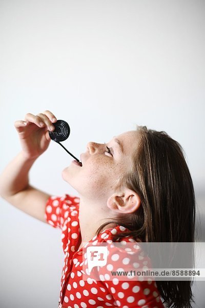 ein kleines Mädchen spielt mit Lakritz