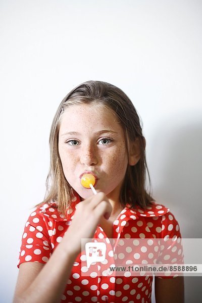 ein kleines Mädchen  das einen Lolli isst.