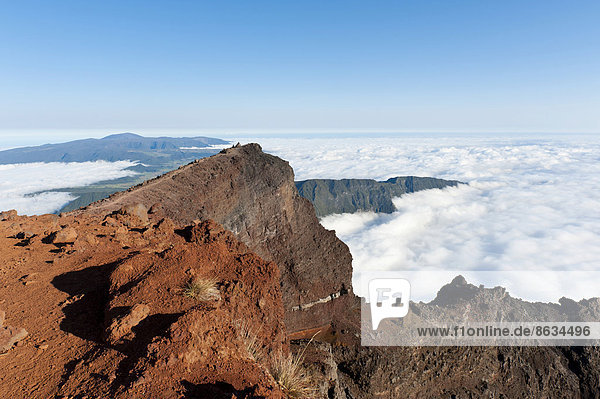 Rotes Vulkangestein auf dem Gipfel  Berg Piton des Neiges  3069 m  über den Wolken  bei Cilaos  französisches Übersee-Département La Réunion