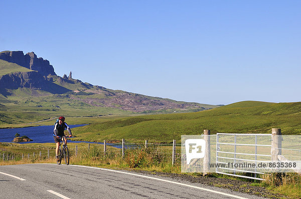 Radfahrer auf der Straße beim Berg The Storr mit der Felsnadel The Old Man of Storr auf der Trotternish-Halbinsel  Ross  Skye and Lochaber  Skye  Schottland  Großbritannien