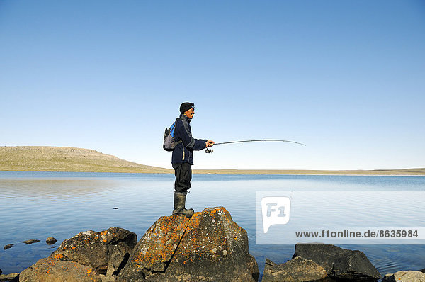 Men of the Inuit people fishing in a lake  Victoria Island  formerly Holman Island  village of Ulukhaktok  Northwest Territories  Canada