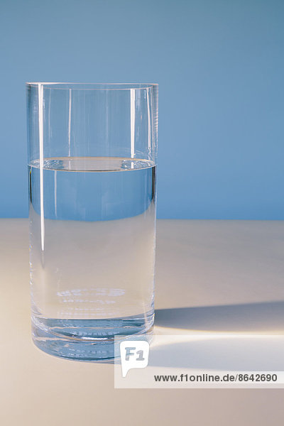 Ein Glas gefiltertes Wasser auf einer weißen Oberfläche.