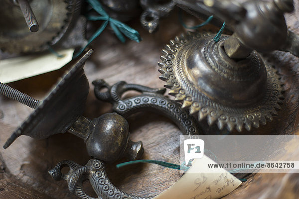 Ein Antiquitätengeschäft mit einer Ausstellung von Gegenständen und Möbeln aus der Vergangenheit. Ziselierte  mit Metall verzierte Gegenstände  Türklopfer und Beleuchtungskörper.