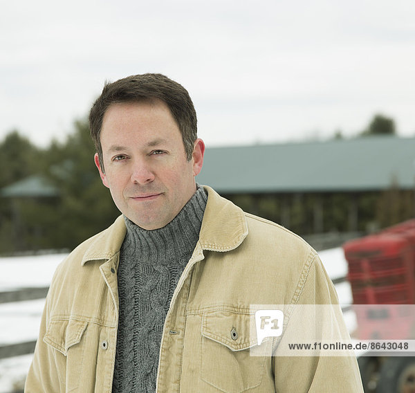 A mature man in a barn coat