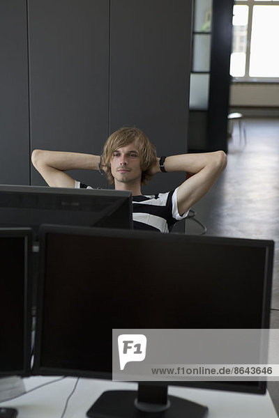 Mann entspannt am Computertisch