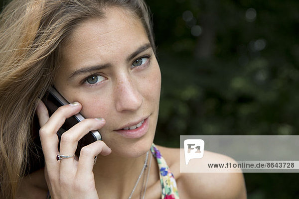 Young woman talking on mobile phone  close-up
