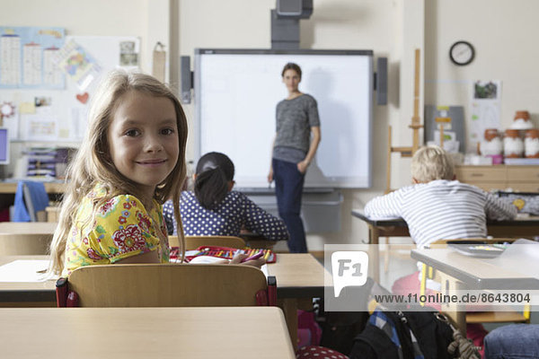 Girl sitting in classroom  smiling
