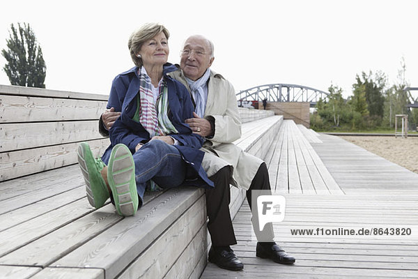 Paar auf einer Treppe im Park sitzend