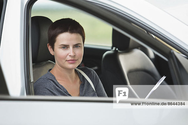 Porträt einer mittleren erwachsenen Frau im Auto sitzend