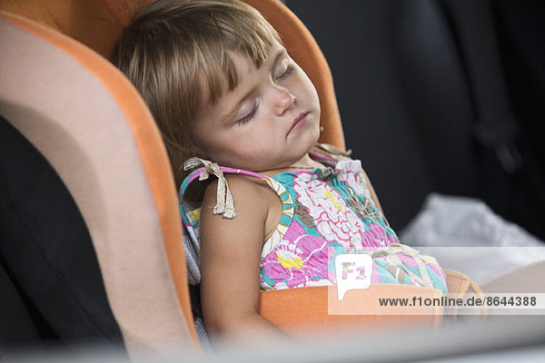 Babymädchen schläft auf Fahrzeugsitz