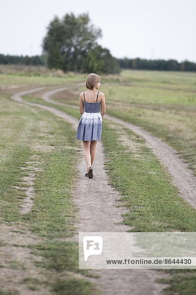 Teenage girl walking on dirt track
