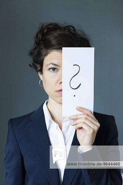 Porträt einer mittleren erwachsenen Frau mit Papier mit Fragezeichen  Nahaufnahme