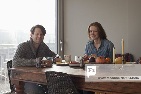 Couple having breakfast at dining table  portrait