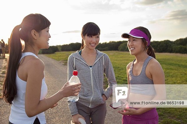 Three young female runners chatting after run