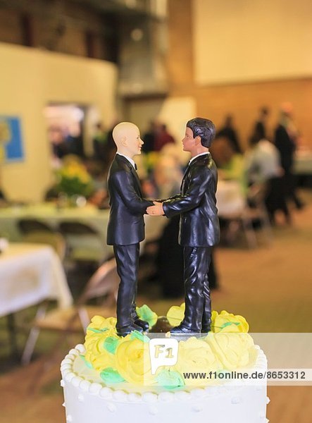 Paar männliche Figuren auf der Hochzeitstorte beim Empfang