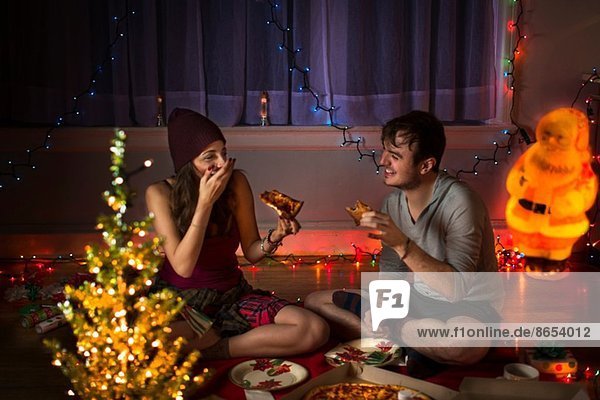 Junges Paar genießt Pizza zu Weihnachten